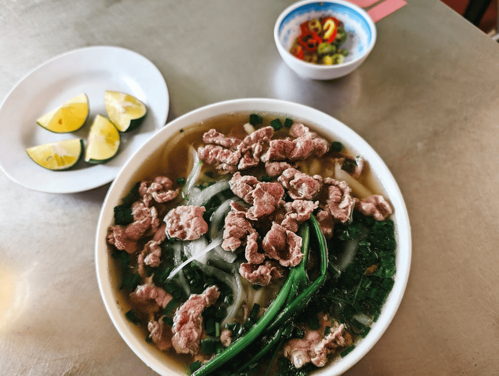 A steaming bowl of Pho Thin Bo Ho, featuring clear broth, tender beef, and fresh herbs (Source: Pexels)